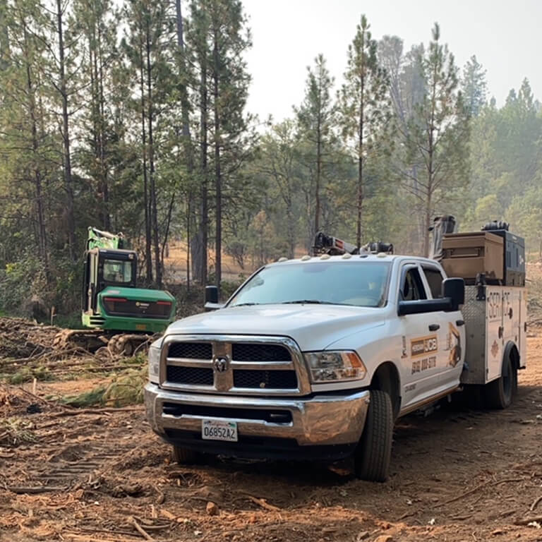 Meridian Service tech working under skid steer